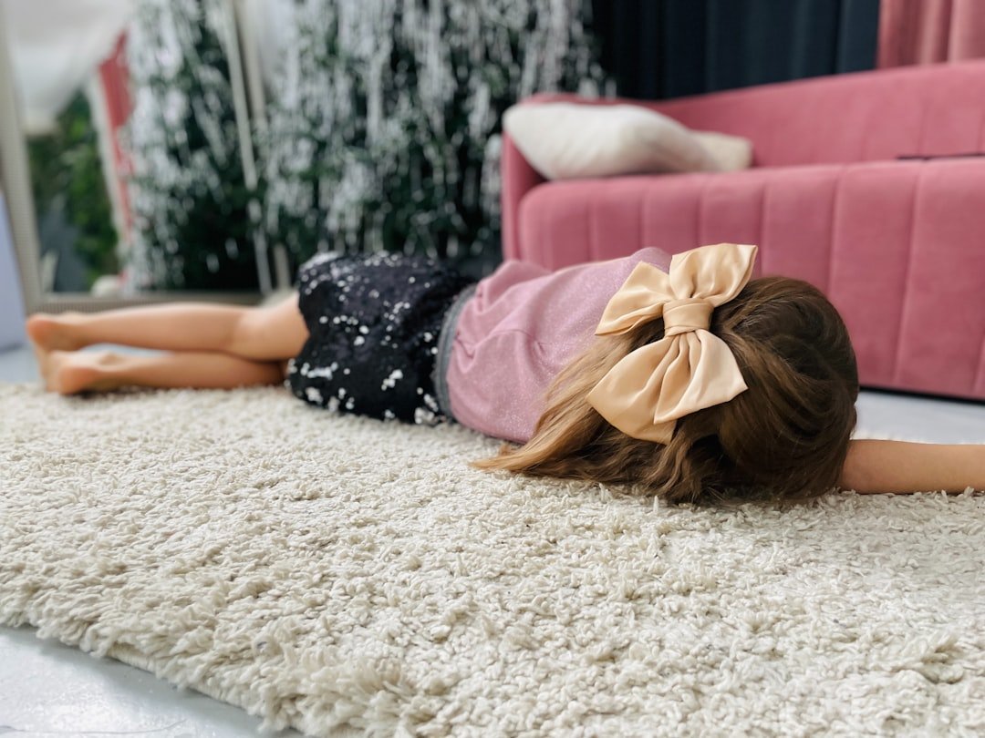 A little girl laying on the floor in front of a mirror