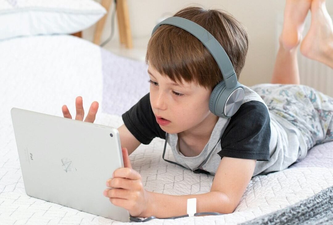 girl in gray t-shirt using white laptop computer